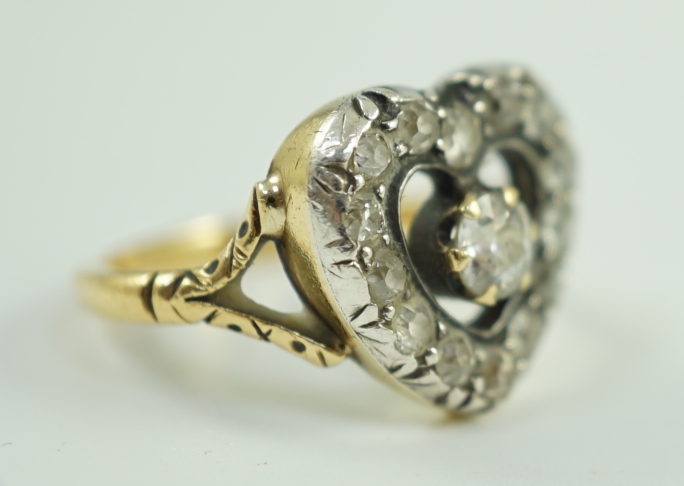 An antique gold and diamond set heart shaped open work cluster ring